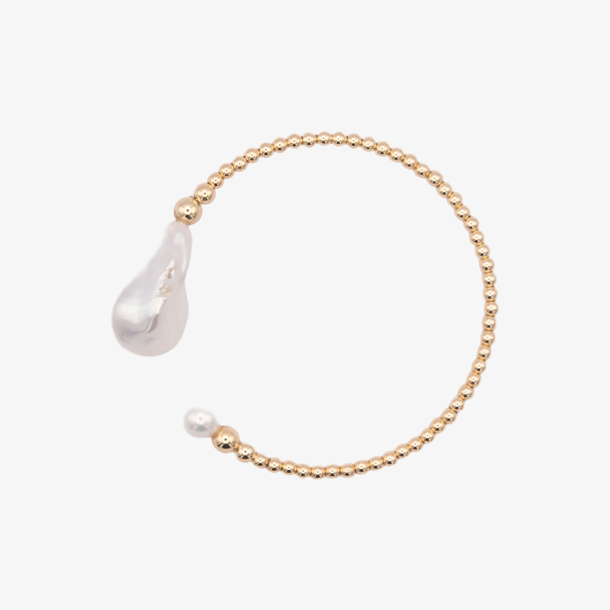 Gold bracelet with a teardrop-shaped pearl on a white background